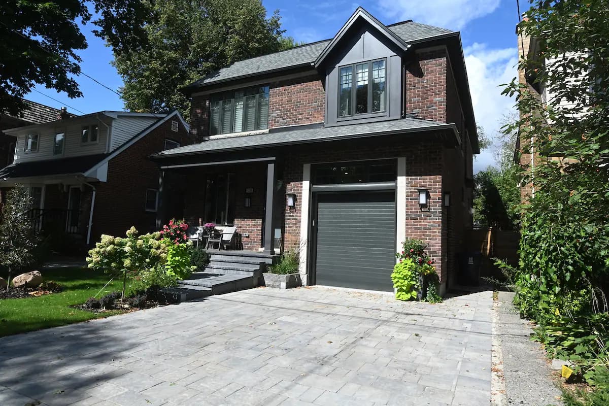 Two-storey home with a new attached garage and stone driveway by CCS Group