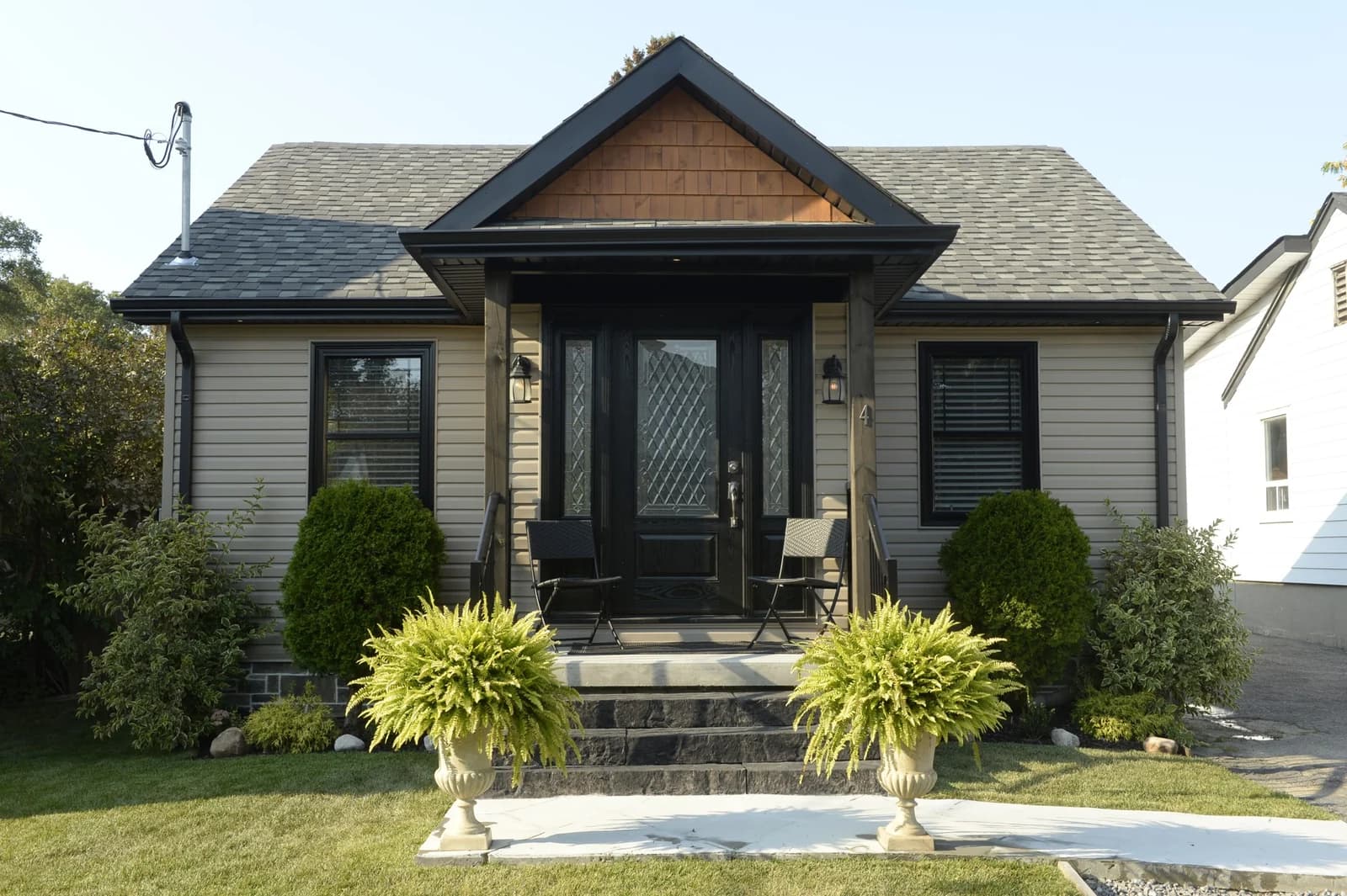 Front of the renovated bungalow with new siding, cedar gable and black trim