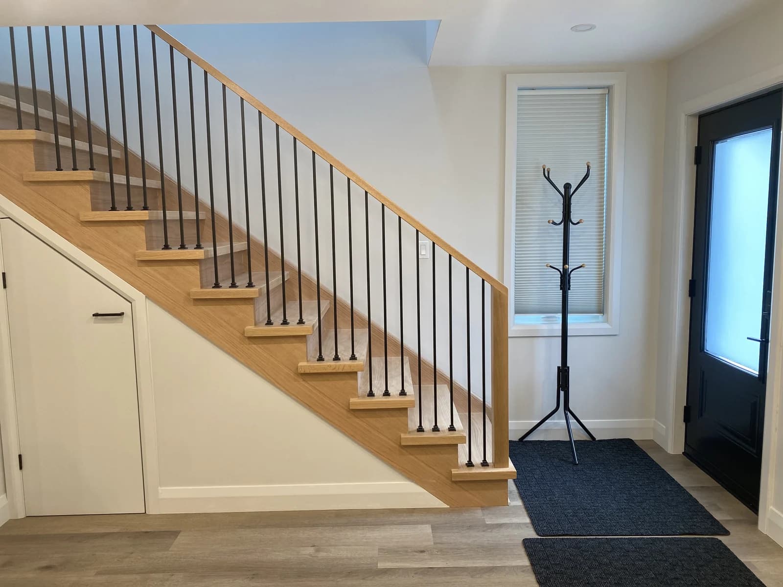 Laneway suite entry with oak stair and black door